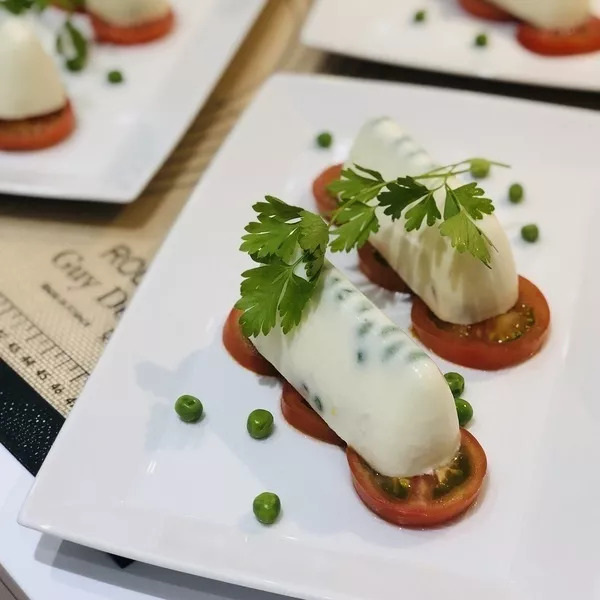 Panna cotta de petits pois & chèvre sur lit de tomates